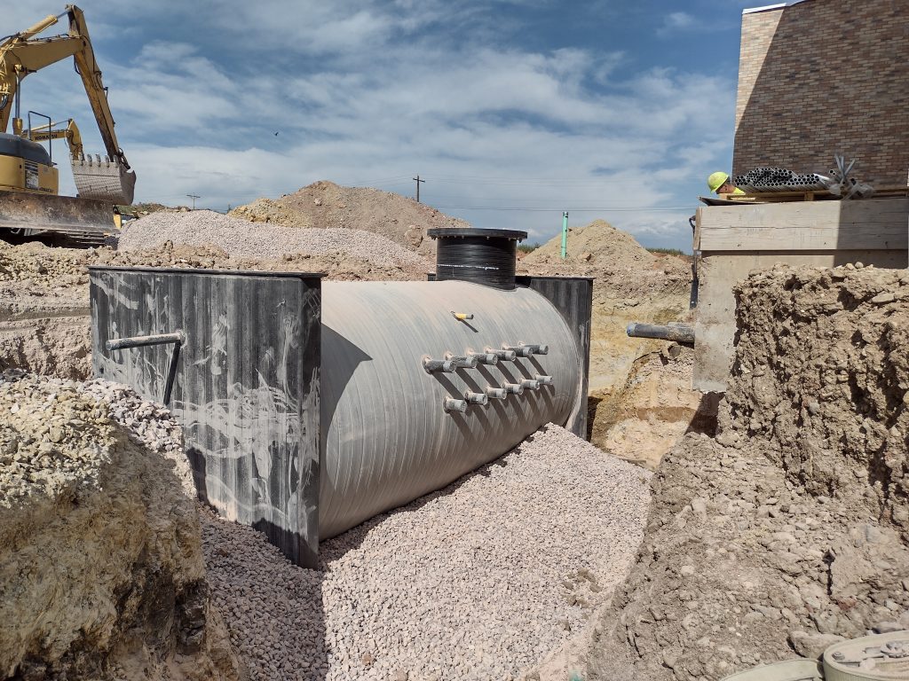 A large tank is in the middle of some rocks.